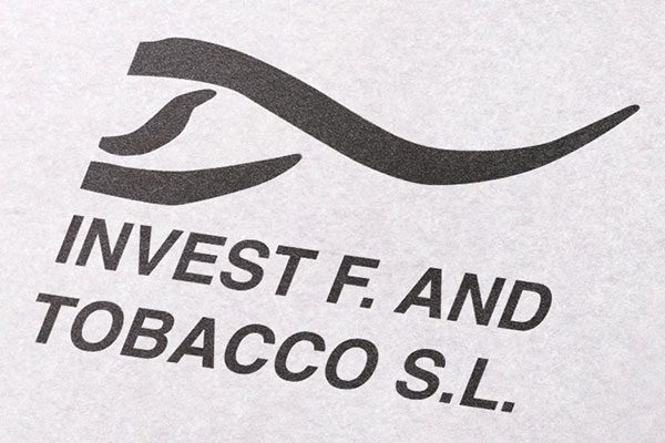 Logotipo de Invest Food and Tobacco en primer plano sobre papel texturizado